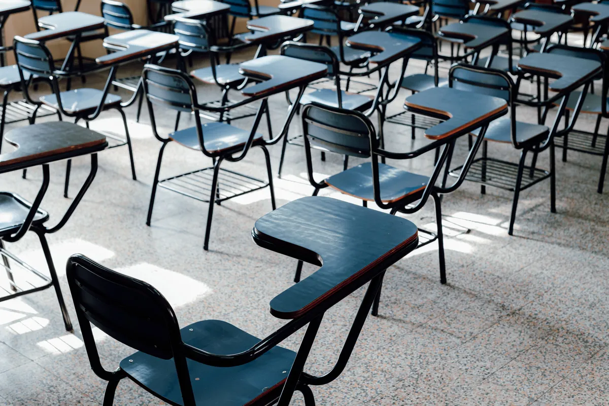 Rows of empty desks and chairs in a classroom