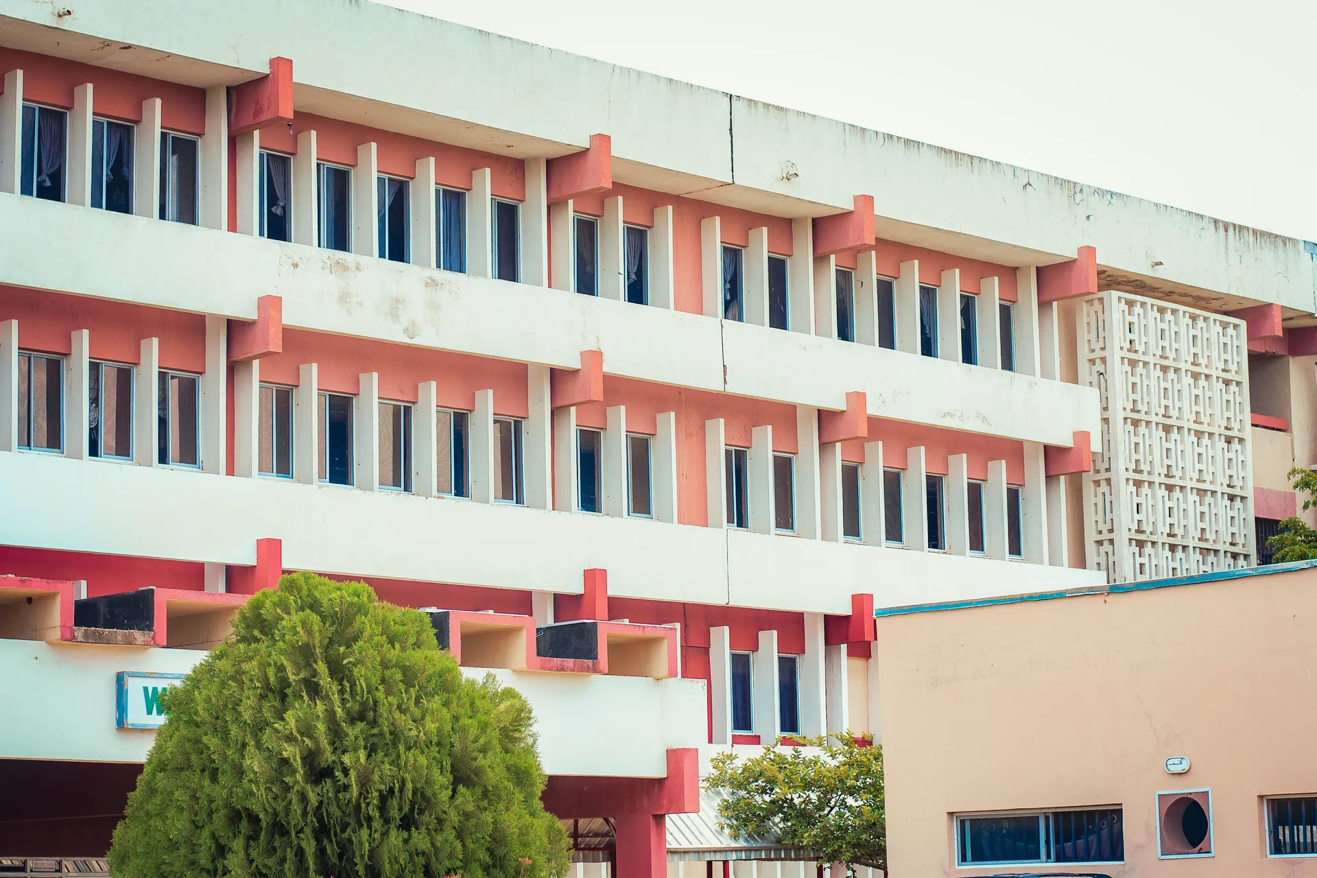 A school building with rows of windows and red pillars